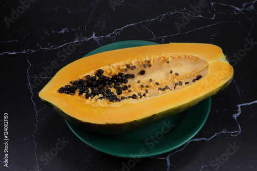 Fresh and organic ripe papaya whole vegetable on the plate. Famous tropical fruit in Asia.
