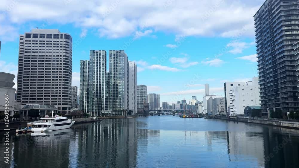 A peaceful canal scene in modern Tokyo with tall buildings and a yacht moored nearby A peaceful canal scene in modern Tokyo with tall buildings and a yacht moored nearby