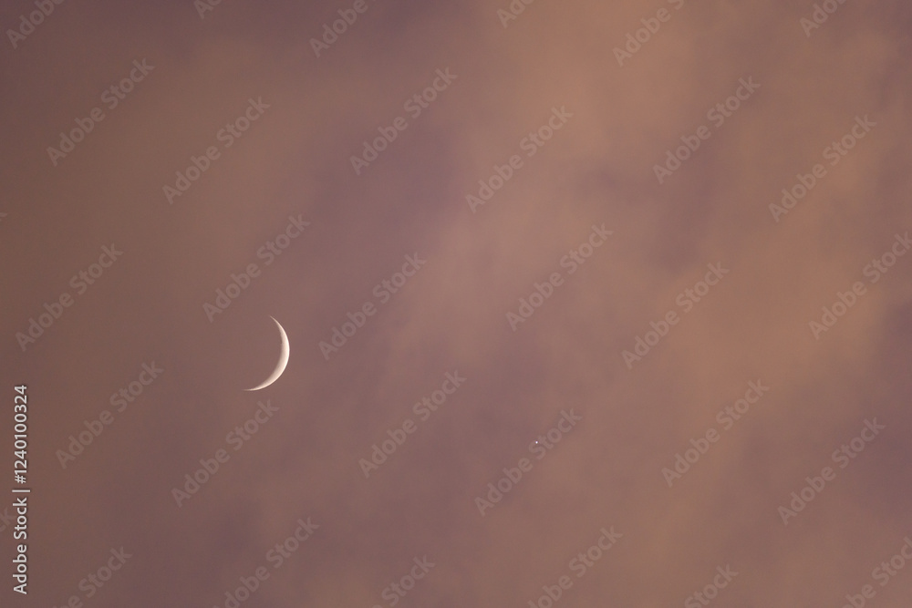 Sliver of the moon and one star, with red skies as the sun sets Sliver of the moon and one star, with red skies as the sun sets