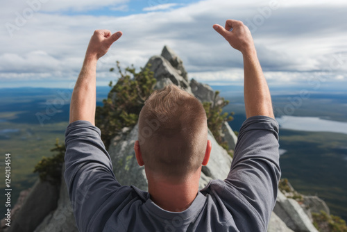 Man standing on a peak with arms raised, symbolizing triumph over adversity