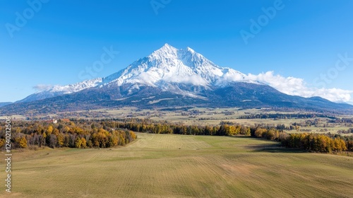 Autumnal valley view of snow-capped peak
