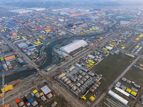 Expansive aerial view of Mahakumbh tent city in daylight, showcasing a vast sea of tents spread across the landscape. A vibrant and grand spectacle of the world’s largest spiritual gathering.
