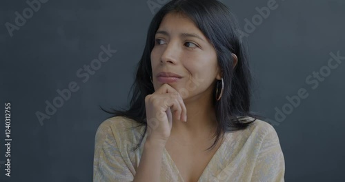 Portrait of creative Hispanic woman thinking raising finger having idea on black background. Problem solving and people concept.