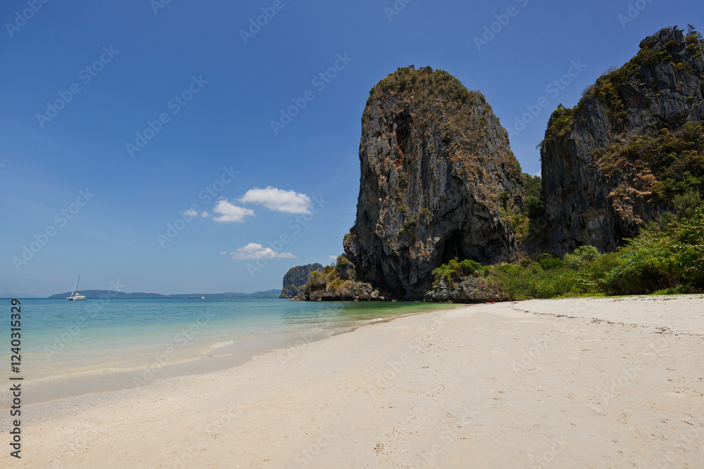 Stunning and steep limestone karst cliffs at the end of empty Phranang (Phra Nang) Cave Beach on a sunny day in Railay, Krabi, Thailand. Stunning and steep limestone karst cliffs at the end of empty Phranang (Phra Nang) Cave Beach on a sunny day in Railay, Krabi, Thailand.