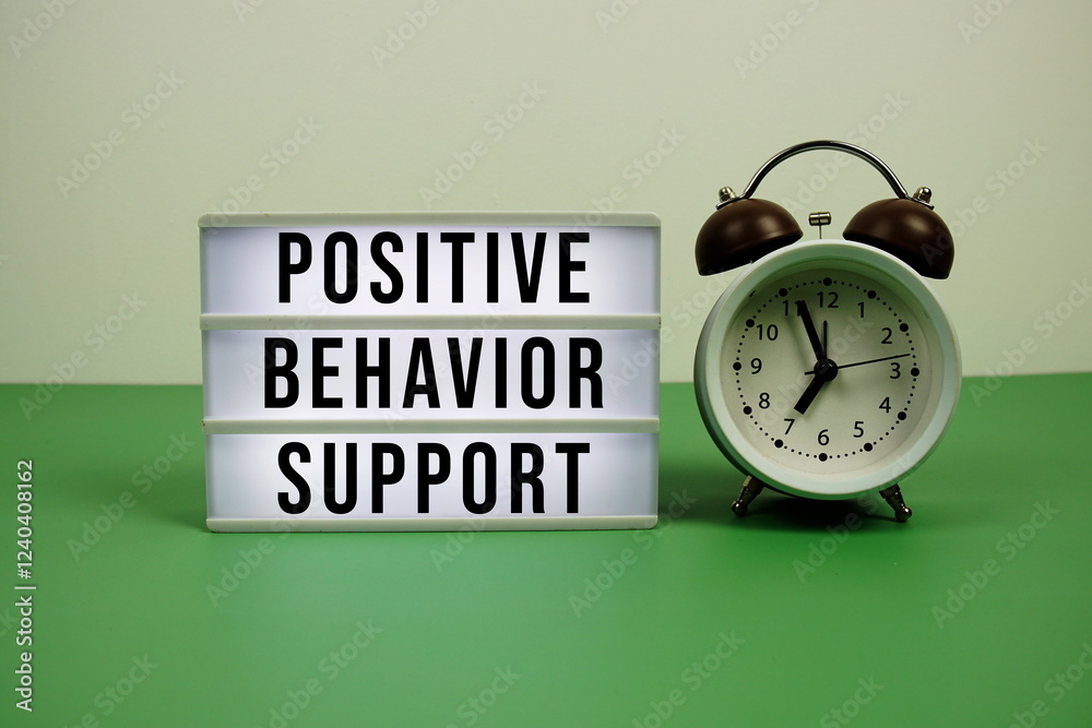 Positive Behavior Support text on light box with alarm clock on green background Positive Behavior Support text on light box with alarm clock on green background