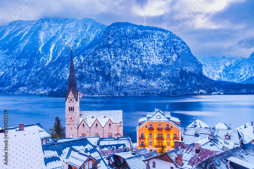 Obraz na płótnie Hallstatt, Austria - Winter snowy twilight of tranquil Alpine village, snow-covered rooftops, serene lake, majestic mountain ridge. w salonie