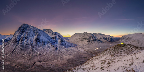 View into Glencoe, Highlands, Scotland. A lone tent wild camping on the peak over looking Glencoe at sunset.