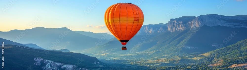 Naklejka premium A vibrant hot air balloon floats above breathtaking mountains, capturing the beauty of nature in a serene landscape during a clear day.