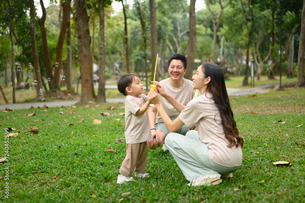 Parents and little child playing with bubbles in nature. Family bonding concept Parents and little child playing with bubbles in nature. Family bonding concept