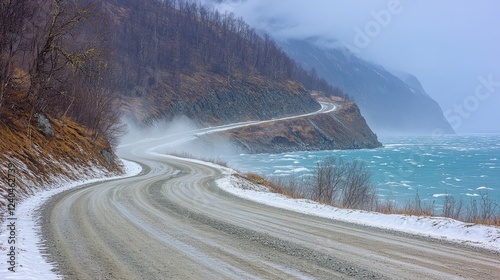 Dramatic Coastal Winter Road with Snowy Curves, Misty Mountains, and Turquoise Ocean Waves - Explore Scenic Beauty and Adventure in Serene Winter Landscapes photo