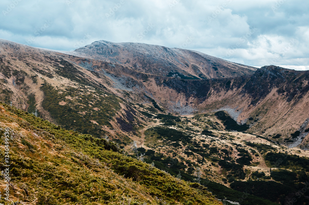 Obraz premium Rugged Mountain Landscape Under Cloudy Sky