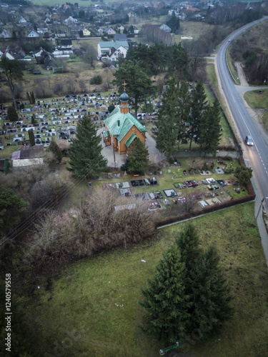 Aerial view of St. Nicholas Miracle Chapel surrounded by a tranquil cemetery and lush trees, Rudamina, Lithuania. photo