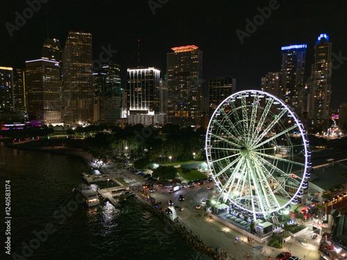 Aerial view of vibrant downtown skyline with illuminated skyscrapers and a ferris wheel, Miami, United States.