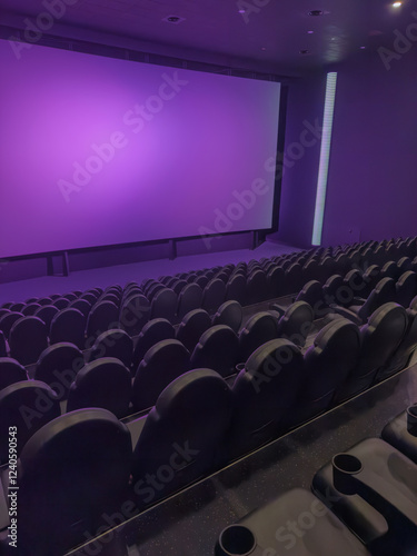 Empty cinema auditorium with rows of seats and projector screen in purple tone