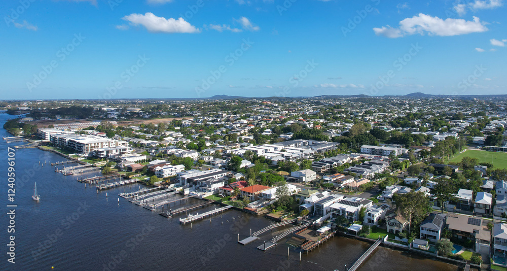 Aerial view of Brisbane River with beautiful homes and a sailing boat near Bulimba Barracks, Brisbane, Australia. Aerial view of Brisbane River with beautiful homes and a sailing boat near Bulimba Barracks, Brisbane, Australia.