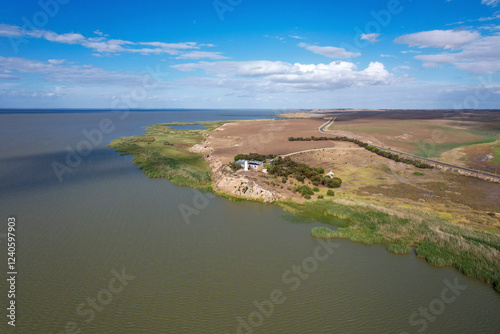 Aerial view of Point Malcom Lighthouse and the tranquil waters of Lake Alexandrina with a scenic coastline, Meningie, Australia. photo