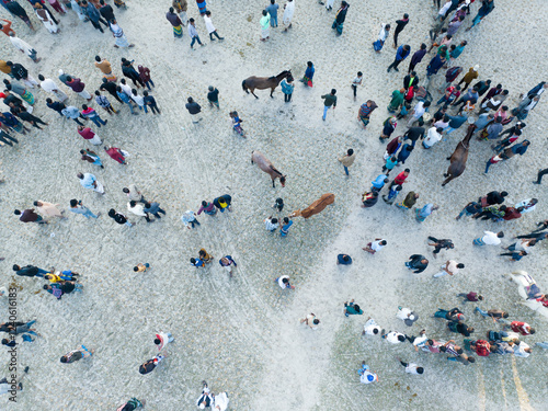 Aerial view of a vibrant community gathering with people and horses in a bustling public space, Ghatail, Bangladesh. photo