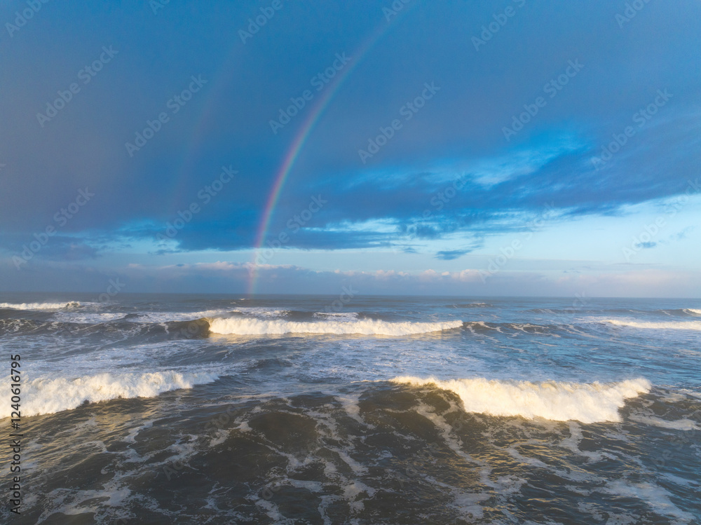 Aerial view of a tranquil dawn over Mocrocks Beach with a colorful rainbow and surf on the Pacific Ocean, Pacific Beach, Washington, United States. Aerial view of a tranquil dawn over Mocrocks Beach with a colorful rainbow and surf on the Pacific Ocean, Pacific Beach, Washington, United States.