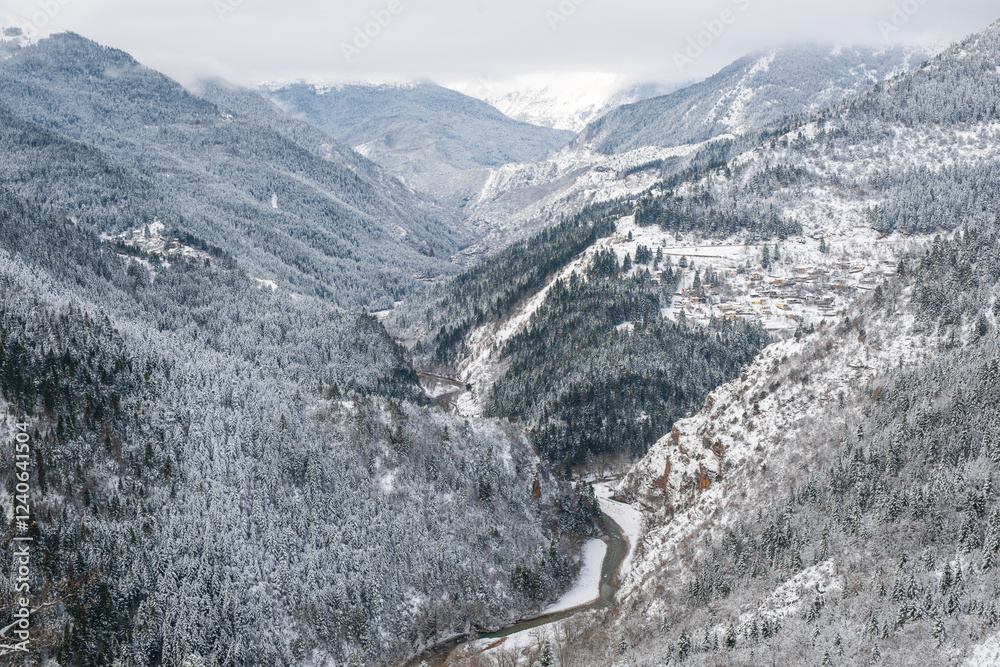 Valley between tall mountains in the winter with snow
