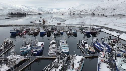 Aerial view of carl mosses harbor with fishing boats and snowy mountains, unalaska, united states.