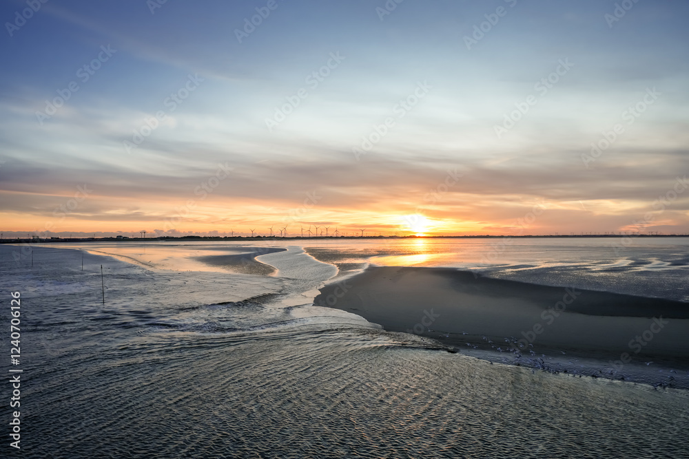 Fototapeta premium Landscape near Dagebüll. Nature with sunrise on the North Sea coast. Rising sun on the sea.