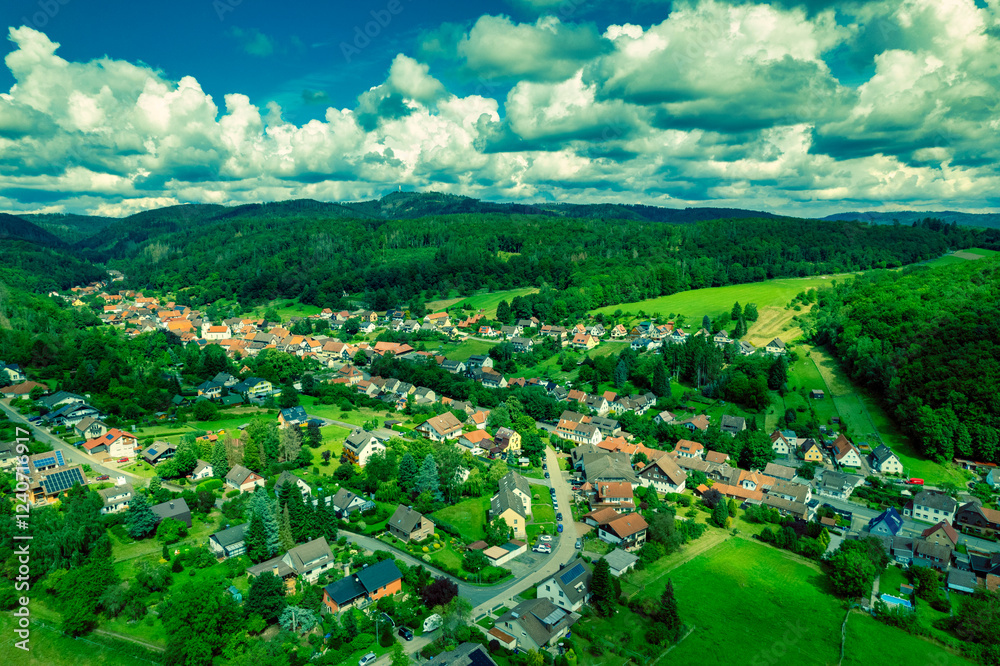 Vibrant German Village Nestled in a Valley Surrounded by Lush Greenery and Picturesque Mountains on a Bright Sunny Day