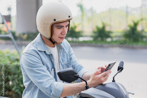 Wallpaper Mural Asian man looks at map on phone while riding a motorbike
 Torontodigital.ca