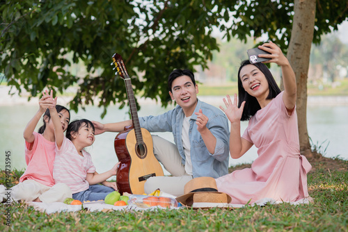 Young Asian family having a picnic in the park on the weekend
