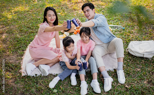 Photography Young Asian family having a picnic in the park on the weekend