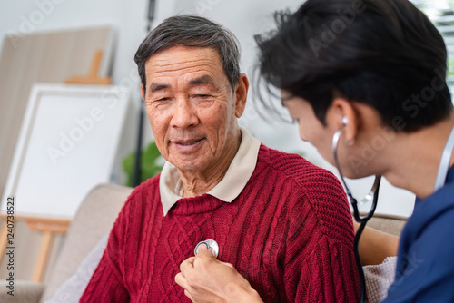 Photos Nurse using stethoscope to check elderly man's heart during a home health check-