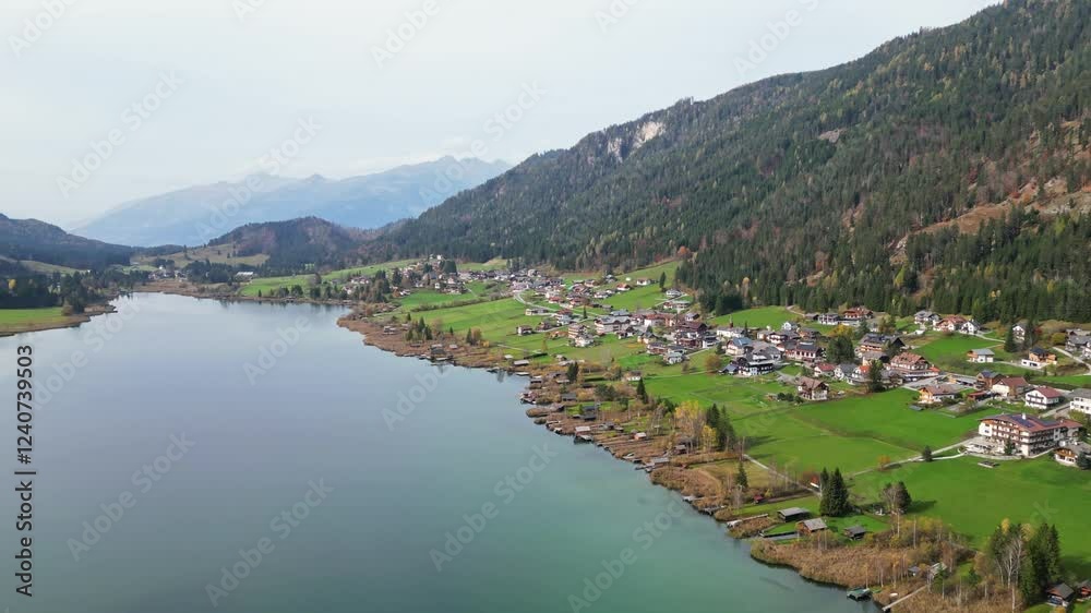 Aerial view of idyllic autumn landscape with serene Weissensee lake, picturesque village, and tranquil mountains, Carinthia, Austria. Aerial view of idyllic autumn landscape with serene Weissensee lake, picturesque village, and tranquil mountains, Carinthia, Austria.