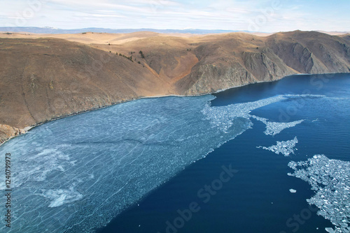 Lake Baikal in the spring when the ice is melting. Beautiful view of the mountains around the lake, ice floes floating. Aerial view photo