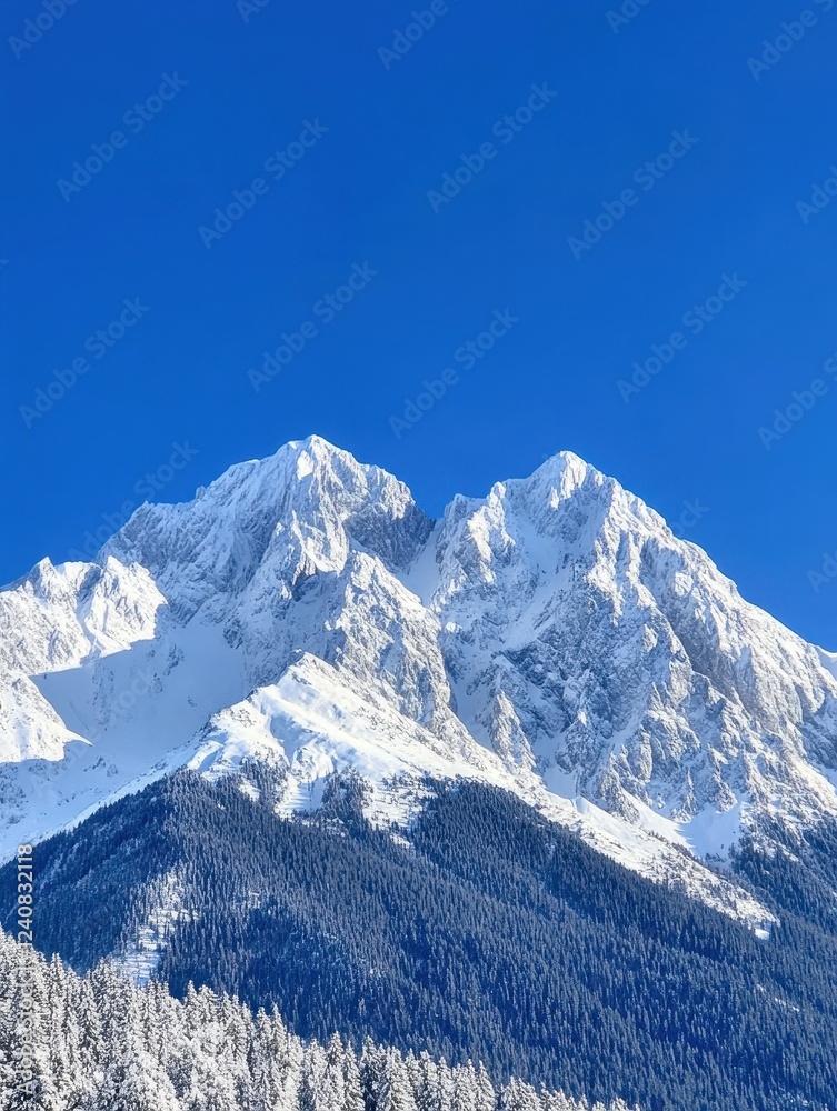 Obraz premium Majestic snow capped mountain peak against a vibrant blue sky