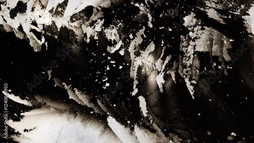 Black ink expanding and mixing on white background