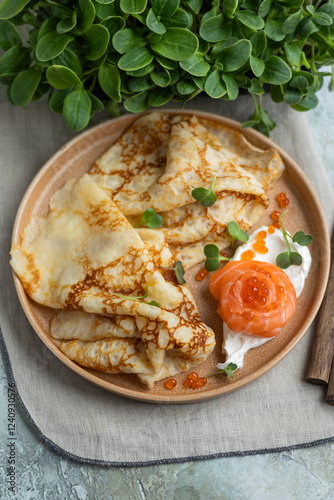 Pancakes with salmon and red caviar.