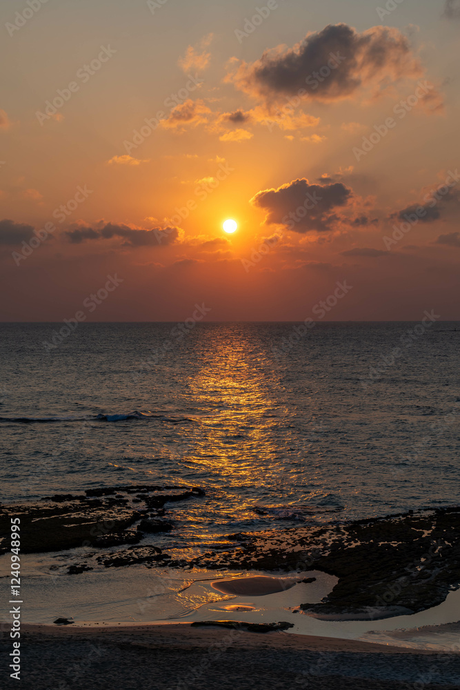 Naklejka premium Orange sunset at a far north beach near Lebanon on the Mediterranean Sea. 