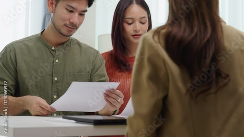 asian financial advisor presenting charts and data on a tablet during couple client meeting.financial planning and decision-making