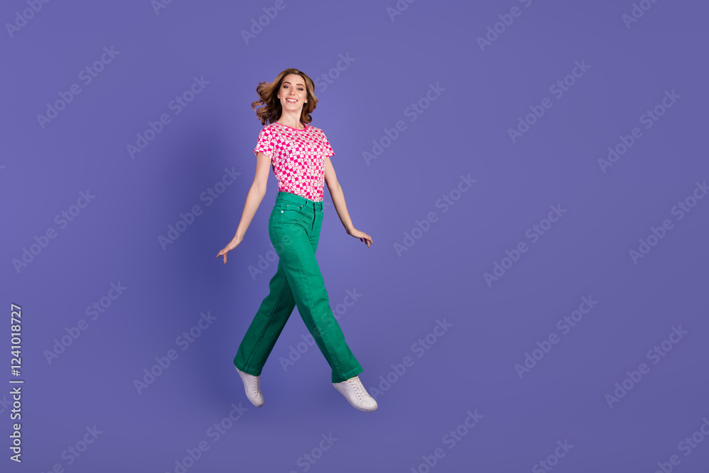 Smiling Young Woman Posing Vibrantly in Colorful Outfit on Purple Background Smiling Young Woman Posing Vibrantly in Colorful Outfit on Purple Background