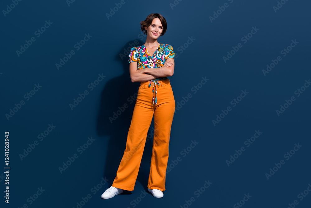 Fototapeta premium Full size photo of attractive young woman crossed hands confident pose dressed flared pants clothes isolated on dark blue color background