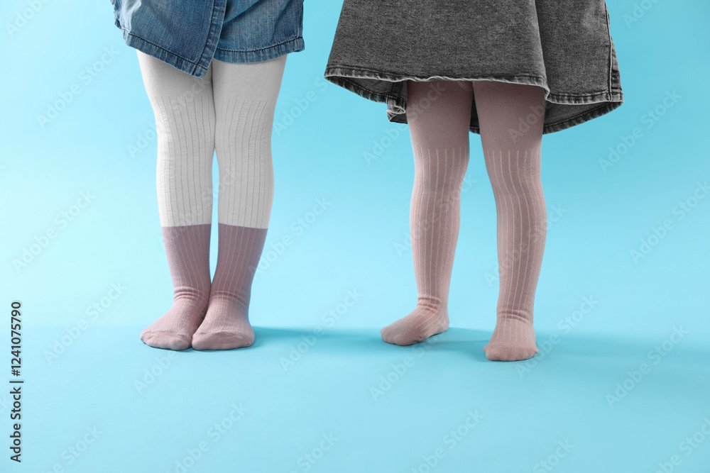 Kids wearing tights on light blue background, closeup Kids wearing tights on light blue background, closeup
