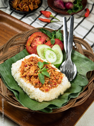 Indonesian nasi bakar, grilled rice, Chilli Shredded chicken is served on a bed of rice, garnished with vegetables, showcasing vibrant colors and fresh ingredients