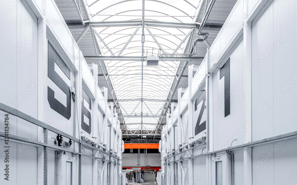Obraz premium A large industrial building with a white roof and orange lights