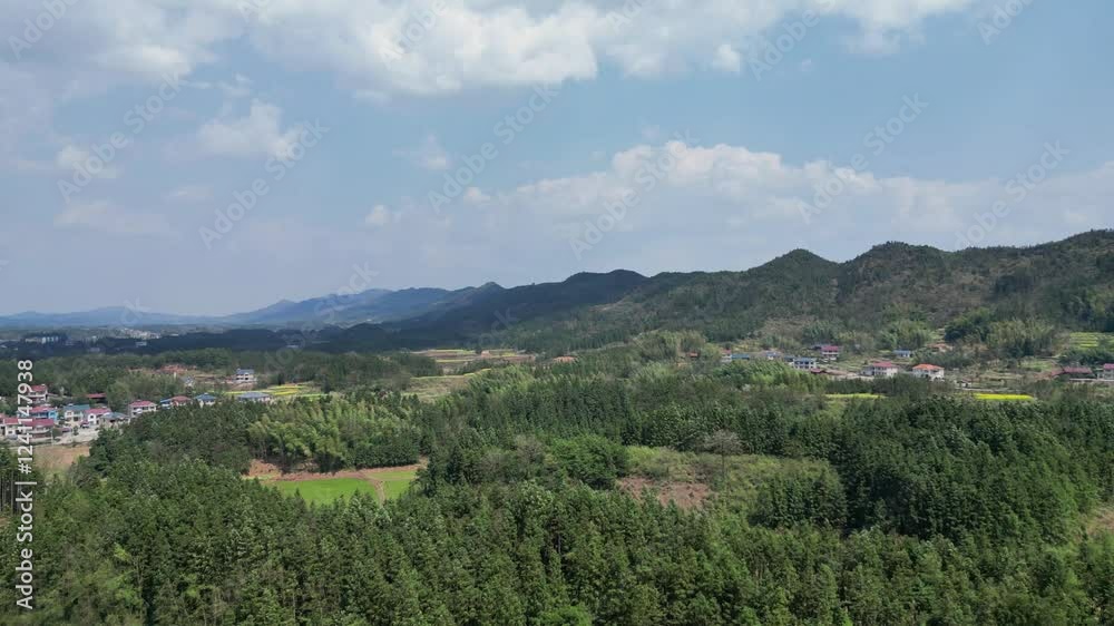 Scenic view of lush mountains and villages in rural China during a sunny afternoon Scenic view of lush mountains and villages in rural China during a sunny afternoon
