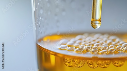 A closeup of a sample of graphene oxide suspended in a clear liquid with tiny bubbles forming around it showcasing the unique dispersive nature of the material in a laboratory beaker.