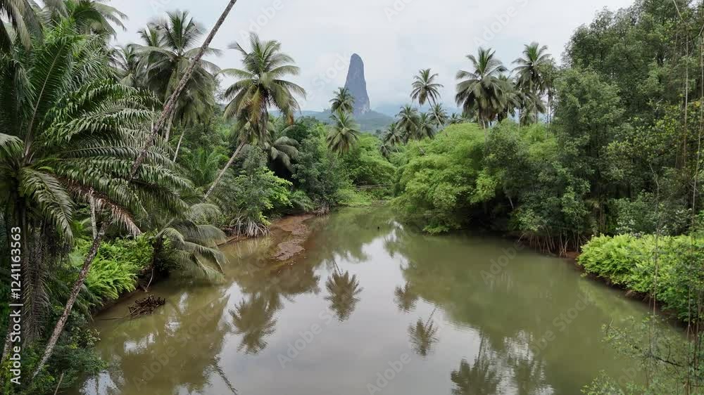 Sao Tome and Principe - River and Tropical Forest With Pico Cao Grande. Scenic Jungle Landscape Reflected in Calm Water. Sao Tome and Principe - River and Tropical Forest With Pico Cao Grande. Scenic Jungle Landscape Reflected in Calm Water.