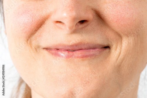 Narrow natural asymmetrical lips. Smiling mouth mimic wrinkles close up. Female face without makeup. photo