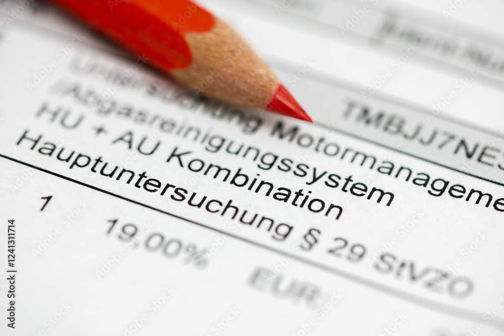 Fototapeta premium Ein Rotstift liegt auf der Rechnung zur TÜV-Hauptuntersuchung und Abgasmessung - Symbolbild