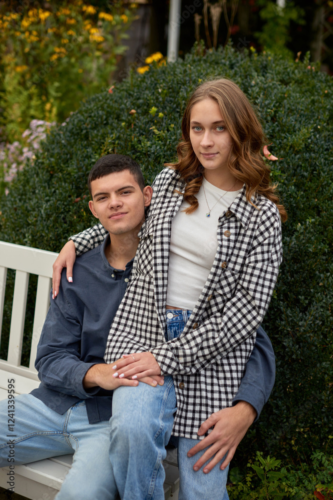 Fototapeta premium Young Cute Female Hugs Boyfriend. In Autumn Outdoor. Lovers Walking in Park. Attractive Funny Couple. Lovestory in Forest. Man and Woman. Cute Lovers in the Park. Family Concept. Happy Couple.
