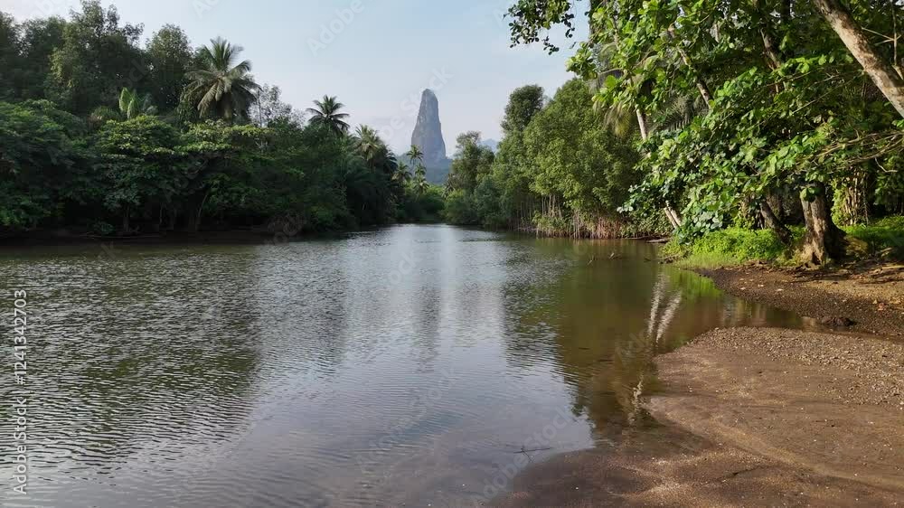 Sao Tome and Principe - River and Tropical Forest With Pico Cao Grande. Scenic Jungle Landscape Reflected in Calm Water. Sao Tome and Principe - River and Tropical Forest With Pico Cao Grande. Scenic Jungle Landscape Reflected in Calm Water.