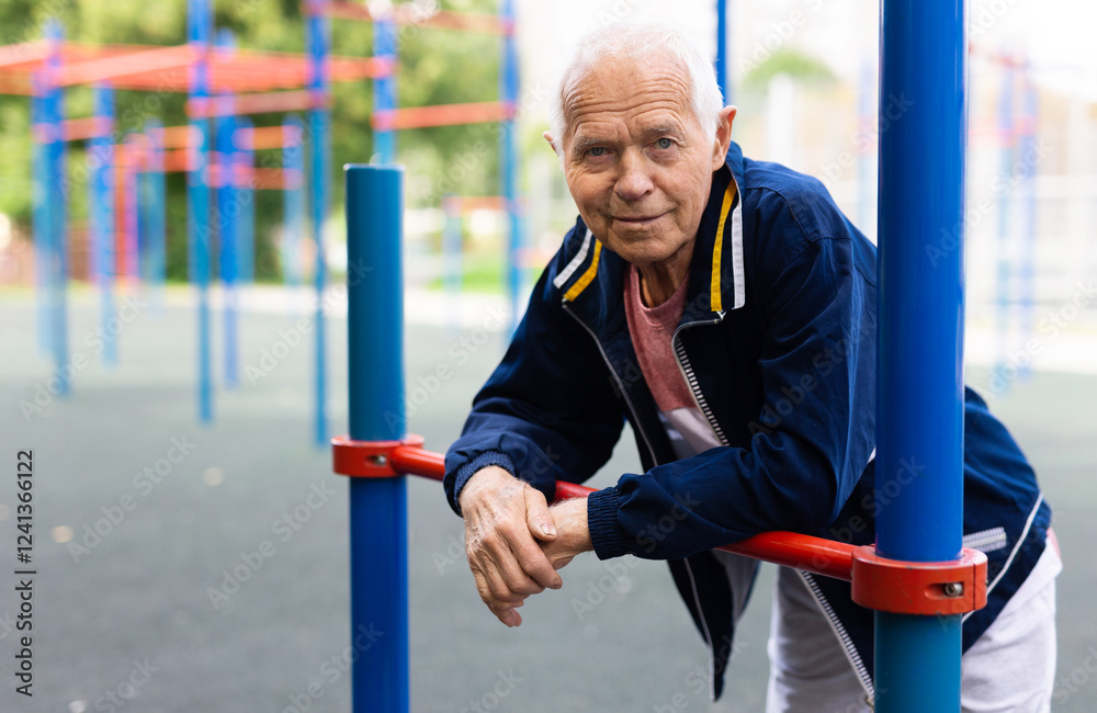 Fototapeta premium Old man in outdoor workout station